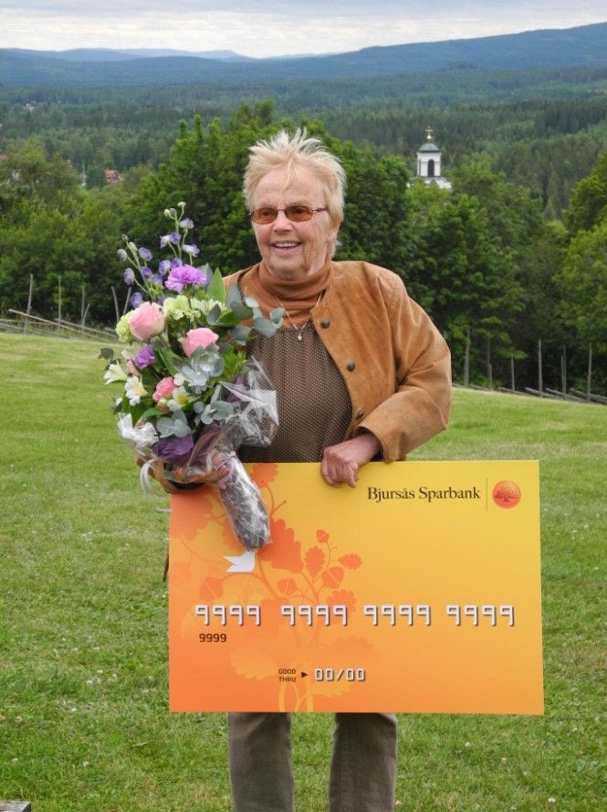 Glad kvinna som håller i en bukett blommor och en gul skylt 