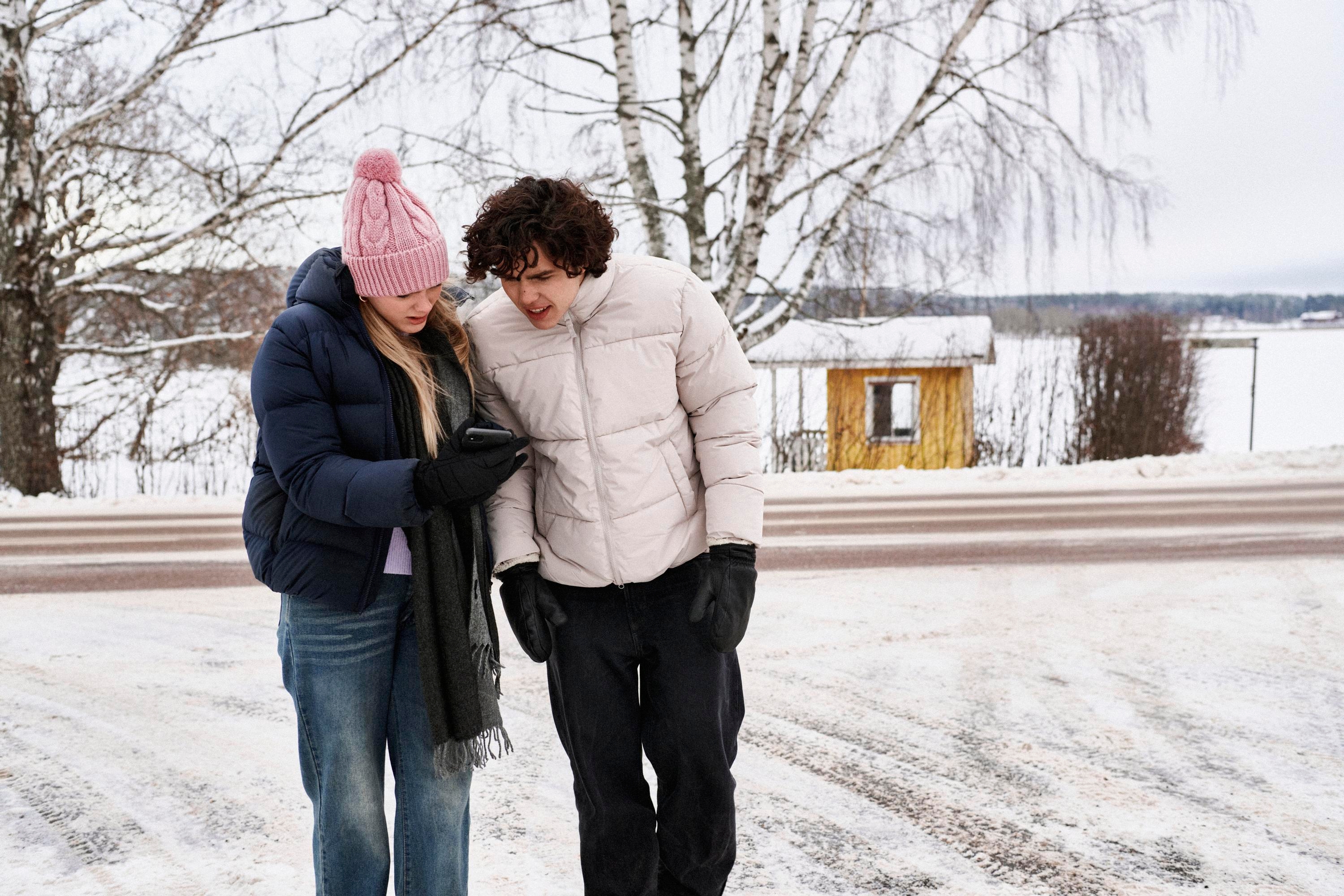 Två unga personer tittar i en mobil