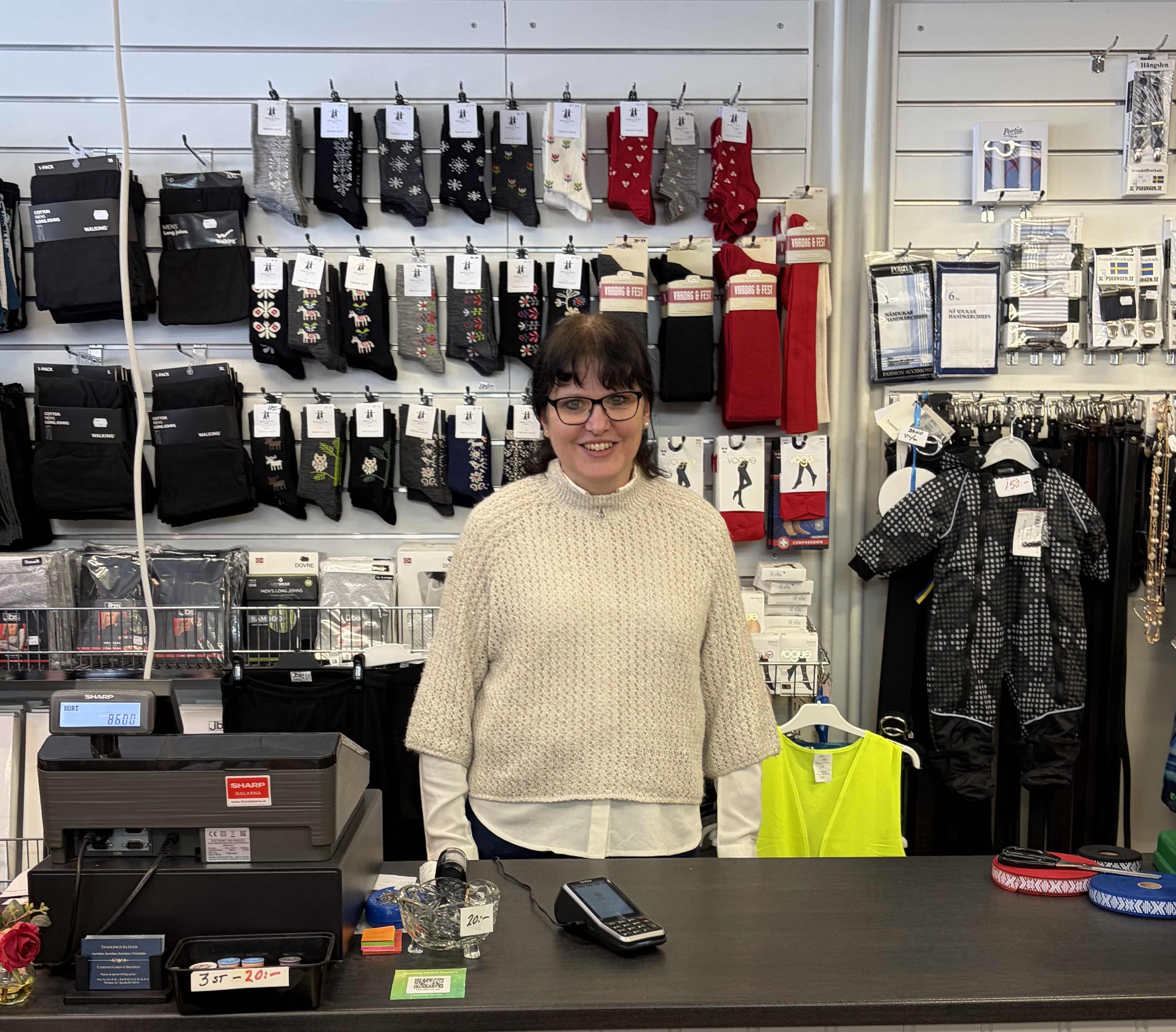 Kvinna och ägare till Svadlings, står bakom en kassadisk inne i butiken
